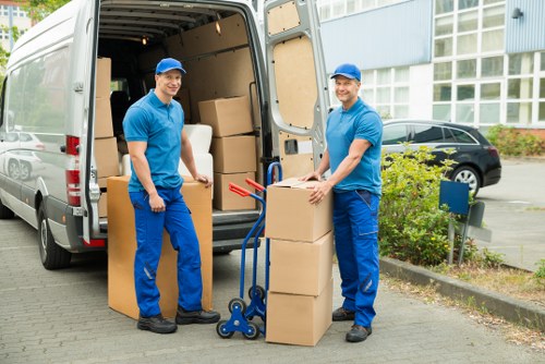 Packed boxes and furniture being loaded into a moving van